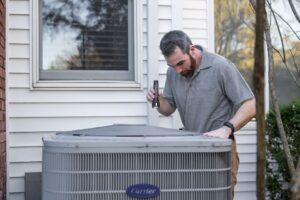 technician inspecting outdoor AC condenser unit