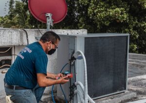 technician using gauges on outdoor AC unit