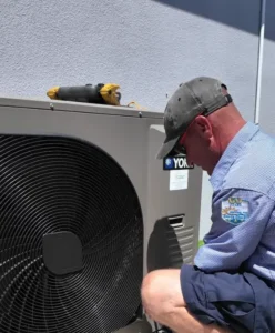technician servicing rooftop commercial AC unit