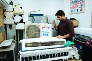 technician servicing rooftop commercial AC unit