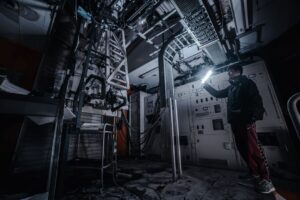 technician inspecting attic ductwork with flashlight